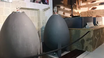 There are three large, grey tanks in an exhibition room.