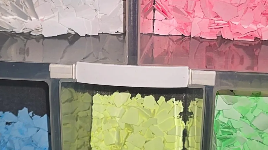 Vier Behälter mit pastellfarbenen Papierschnipseln.