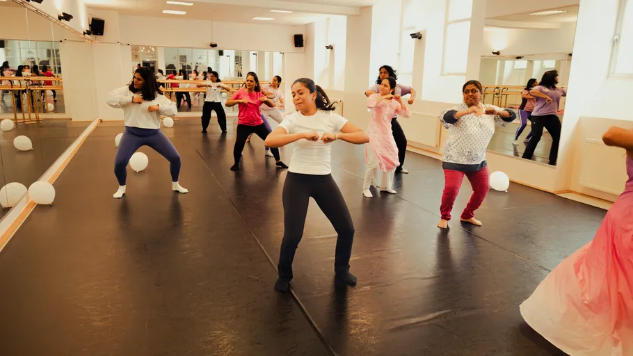 People dancing in a mirrored studio.
