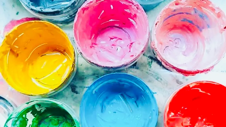 Colorful paint pots arranged on a surface.