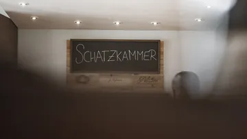 Schild mit 'Schatzkammer' in modernem Interieur.