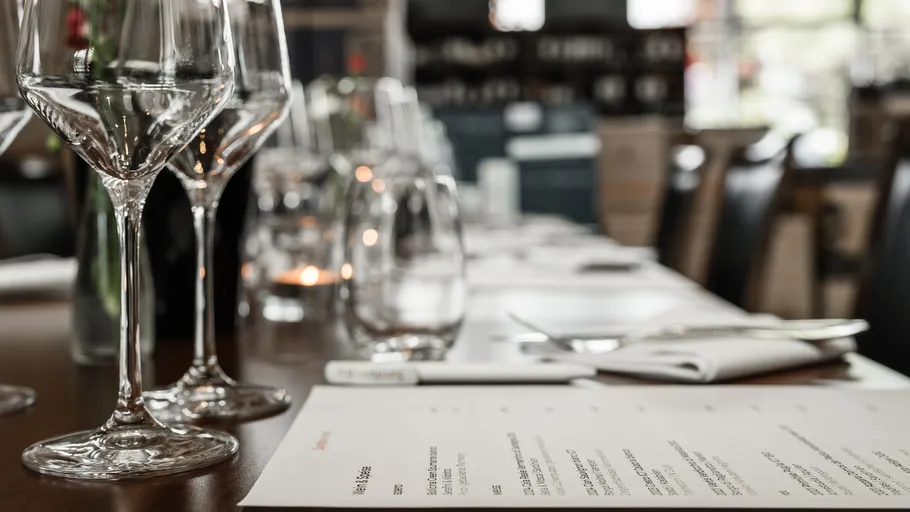 Weingläser und Menü auf Tisch im Restaurant.