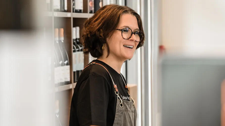 Woman smiling in a wine shop.