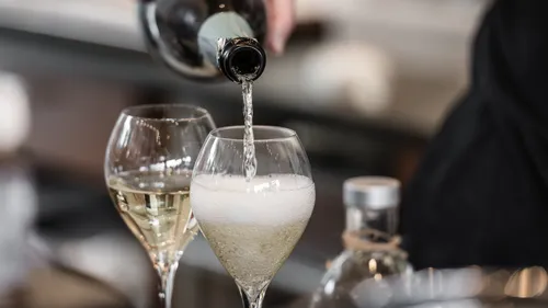 Sparkling wine being poured into glass.