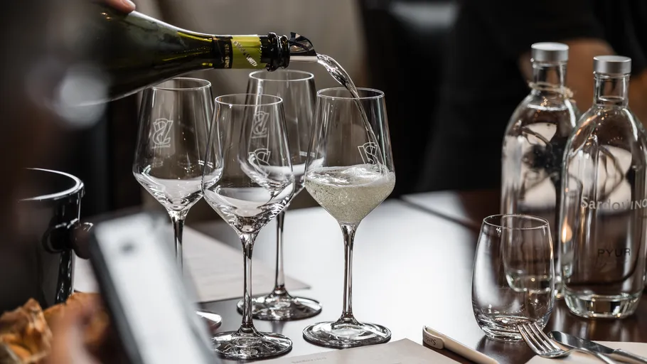 Champagner wird in Gläser am Tisch gegossen.