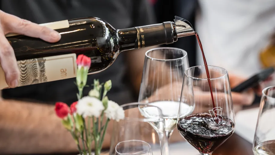 Rotwein wird in ein Glas eingeschenkt.