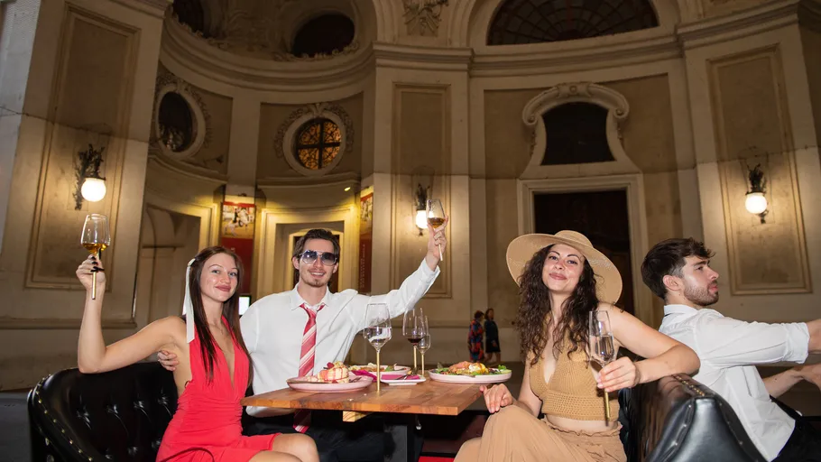 Vier Personen genießen Abendessen in elegantem Ambiente.