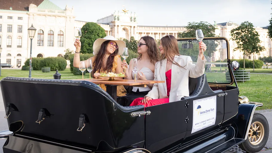 Drei Frauen genießen Getränke in einem Tourenfahrzeug.