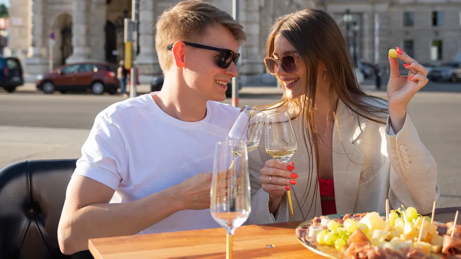 Couple enjoying wine and snacks outdoors.