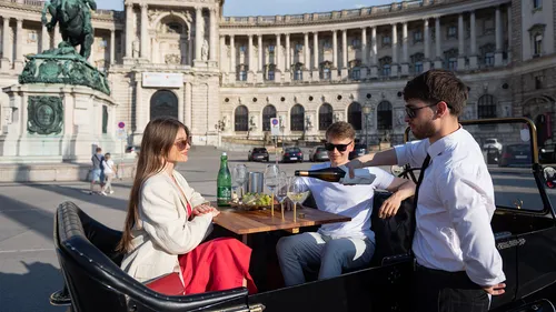 Menschen essen in einem Auto vor historischem Gebäude.