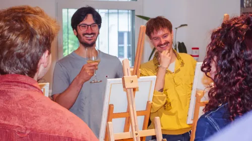 Menschen lächeln und malen im Studio.