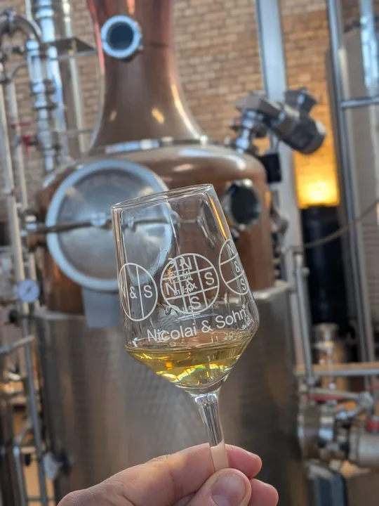 Glass with liquid in a distillery setting.