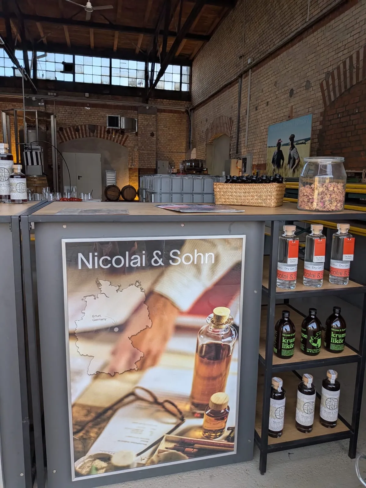 Destillerie-Inneres mit Produktausstellung und Schild.