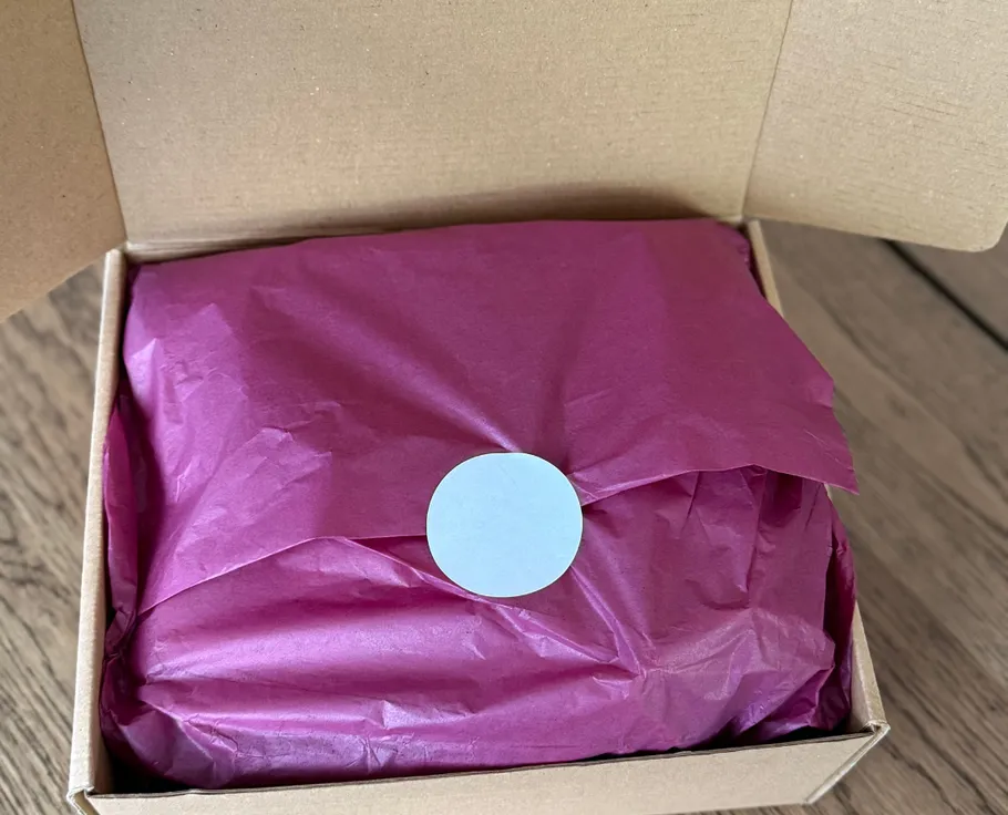 Box with purple tissue paper inside.