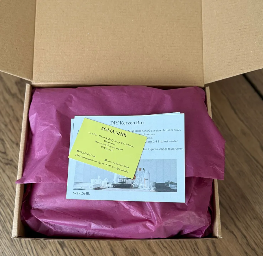 Card and paper atop pink tissue in box.