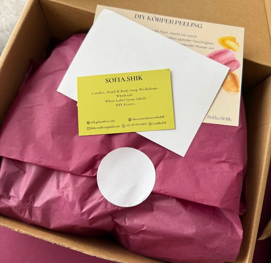 Schachtel mit Geschenkverpackung und Visitenkarte.