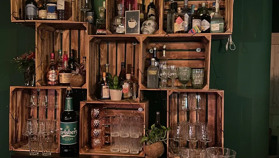 Wooden shelves with bottles and glasses displayed.