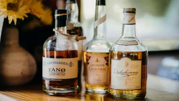 Four whiskey bottles on a wooden table.