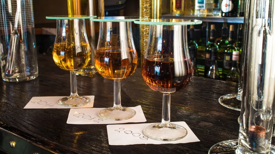 Three filled glasses on a bar counter.
