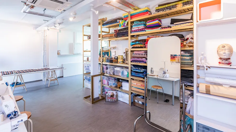 Fabric store with organized shelves and sewing machine.