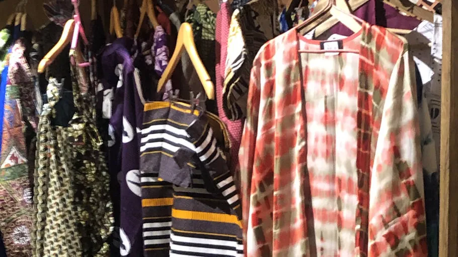 Colorful clothes hanging on wooden hangers.