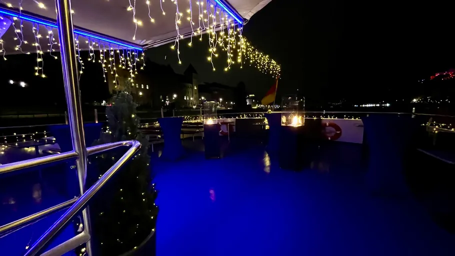 Decorated boat deck with lights at night.