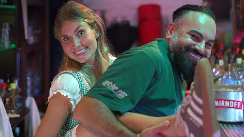 Man and woman posing happily in a bar.