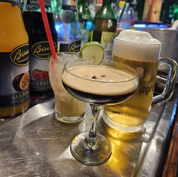 Cocktails and beer on a bar counter.