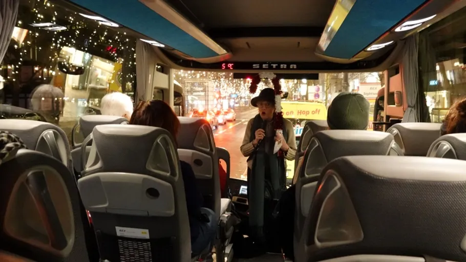 Person mit Mikrofon im Bus bei Nacht.