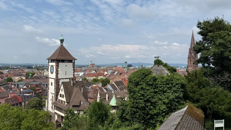 Historischer Uhrturm in malerischer Stadtsilhouette.