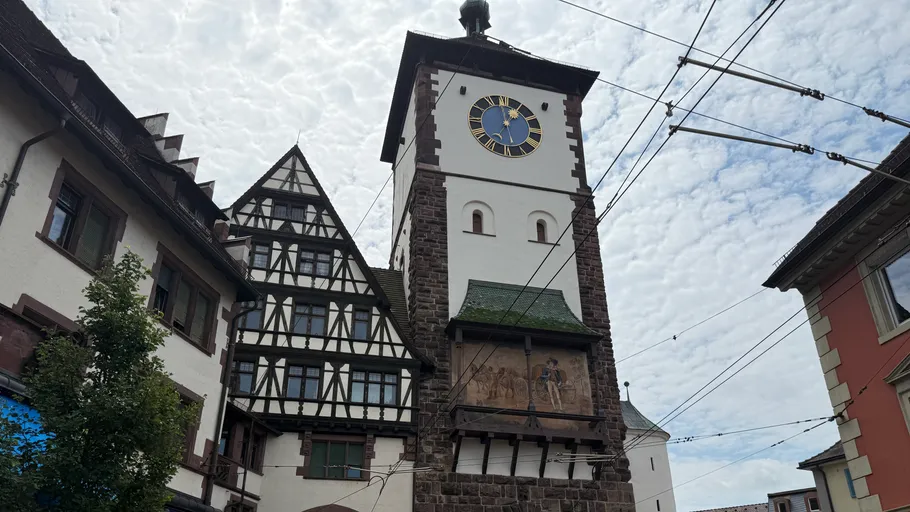 Medieval clock tower among old European buildings.