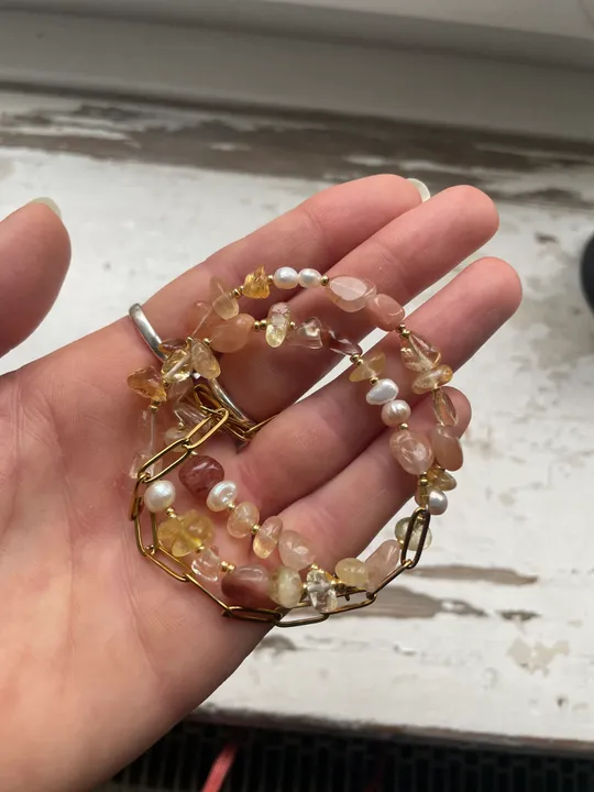 Hand hält Armbänder mit Perlen und Perlen.