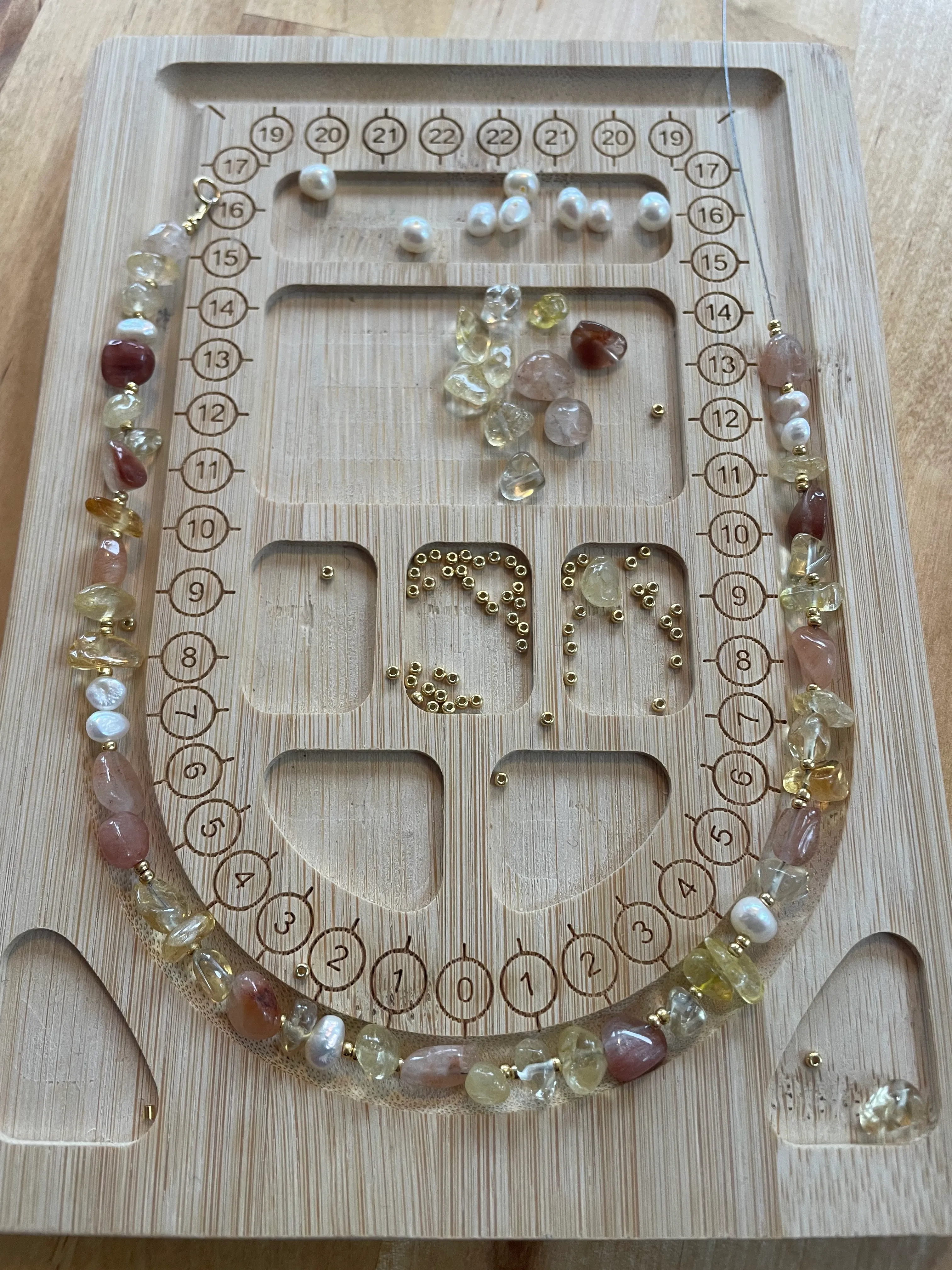 Perlenarrangement-Brett mit bunten Perlen und Perlen.