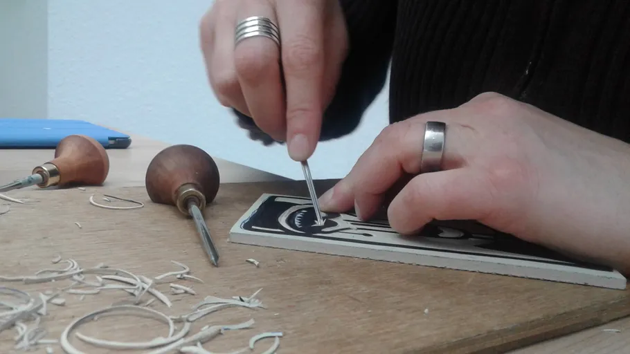Hands carving design on linoleum sheet.