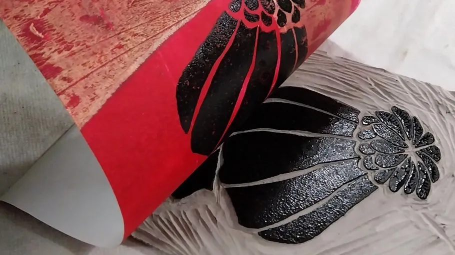 Printed image being lifted from wooden block.