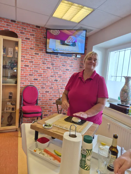 Frau macht Sushi in einer Küchenszene.