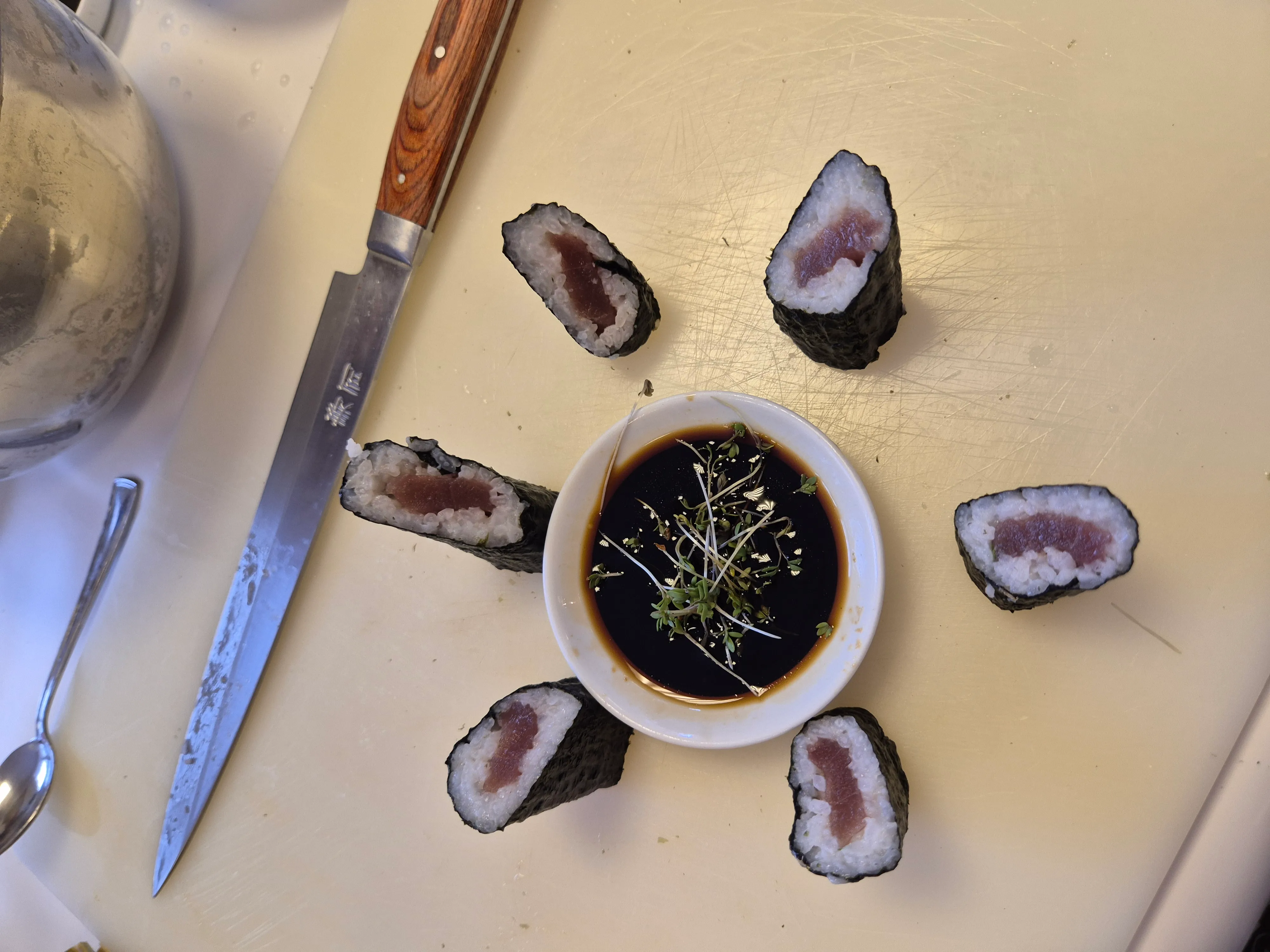 Sushi-Rollen um Sojasauce-Schüssel angeordnet.