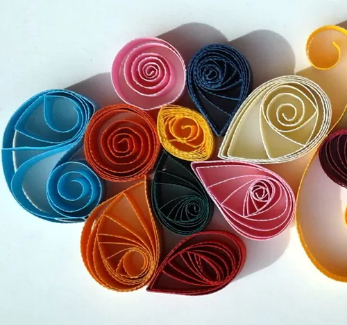 Bunte Papier-Quilling-Kunst auf weißem Hintergrund.