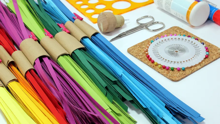 Bunte Papierstreifen mit Bastelwerkzeugen.