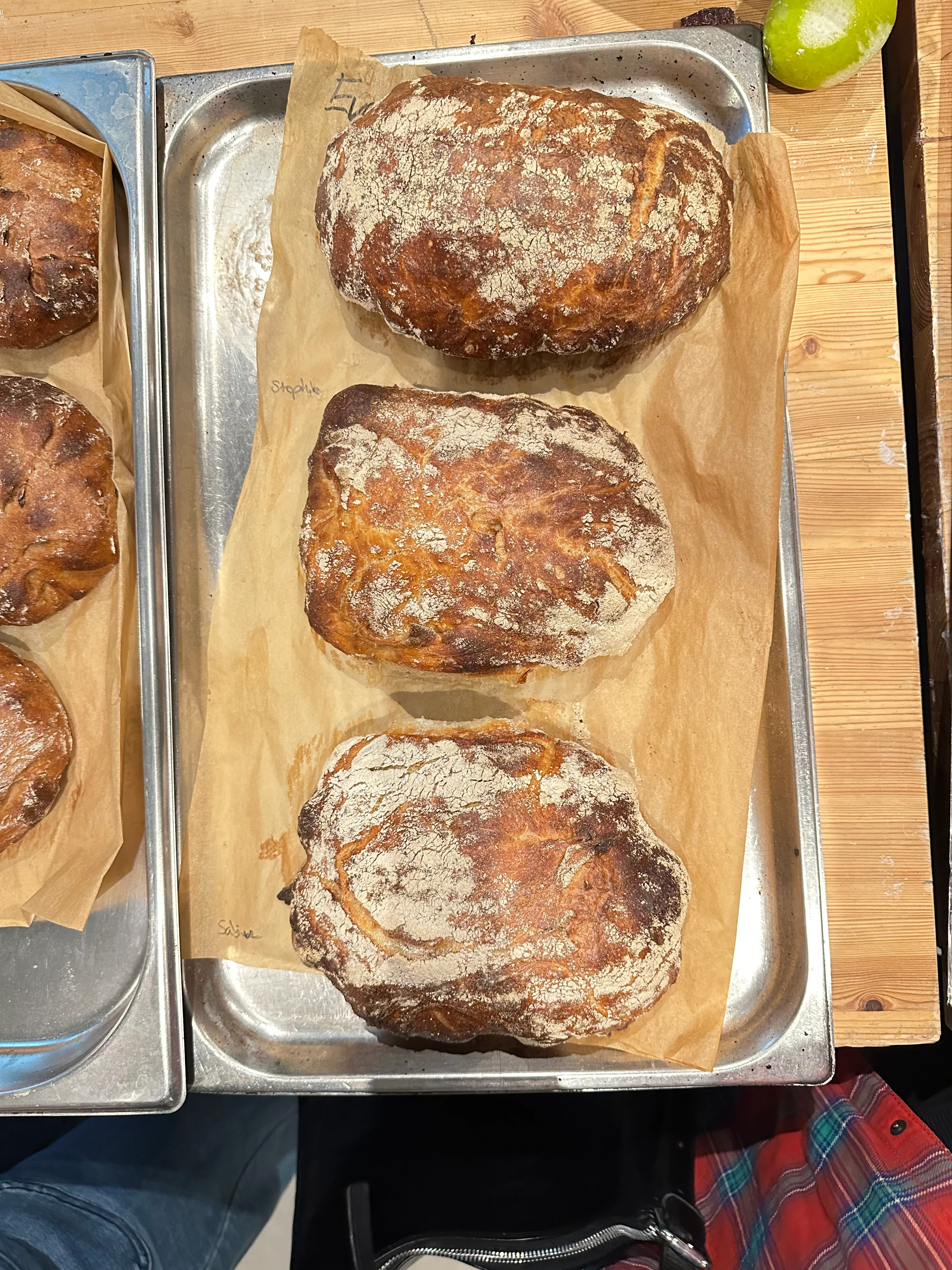 Drei Brote auf Backblechen in der Küche.