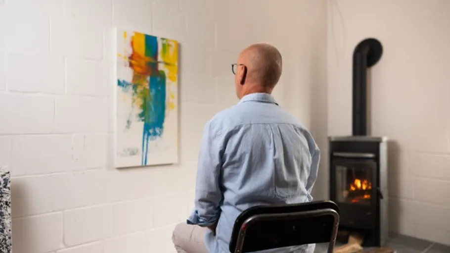Person observing vibrant abstract painting indoors.