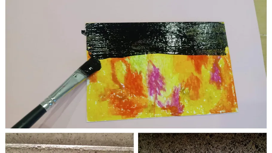 Pinsel malt Schwarz auf bunte Papierkarte.