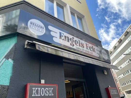 Gebäudeaußenansicht mit Ladenschild und Himmel.
