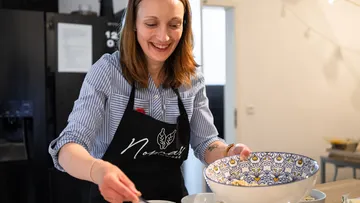 Frau bereitet Essen in einer Küche zu.