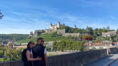 Couple admiring fortress from a bridge.