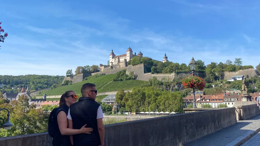 Couple admiring fortress from a bridge.