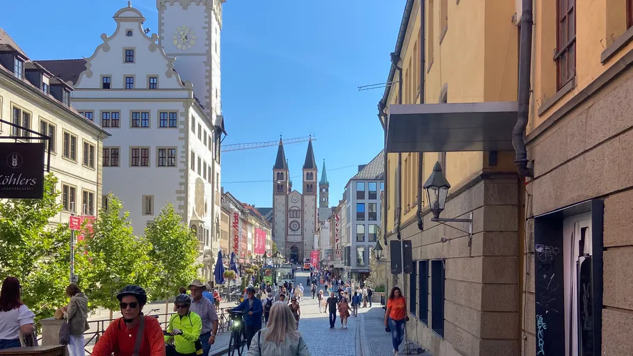 People walking and cycling on a city street.