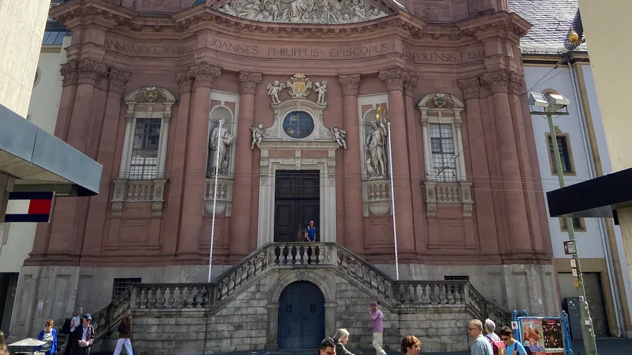 Barockkirchenfassade in städtischer Umgebung.