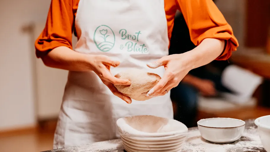 Person kneading dough in a kitchen setting.