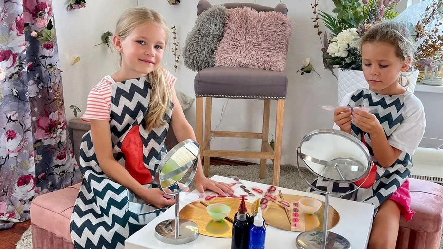 Zwei Kinder basteln drinnen mit Kunstbedarf.